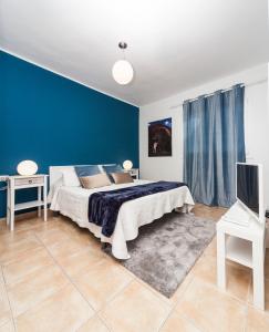 宏达海滩Luxury Suite Sea Front的一间卧室设有一张床和蓝色的墙壁