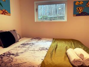 西雅图Arboretum Escape的一间卧室配有一张带窗户和毛巾的床