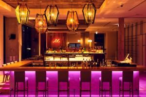 大阪Hotel It Osaka Shinmachi的餐厅内的酒吧拥有紫色的灯光