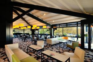 Avignonet-de-LauragaisRelais Fasthotel Port Lauragais的一间带沙发和桌椅的餐厅