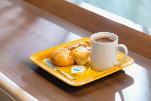 东京Hotel Wing International Shimbashi Onarimon的盘子上摆着糕点和咖啡