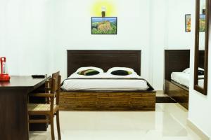 丹不拉Thammenna Eco Cabins的一间卧室配有一张带书桌和一张书桌的床。