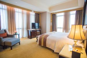 泉州泉州富力万达文华酒店的酒店客房配有一张床、一把椅子和一台电视。