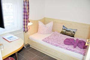 巴贝Pension Vineta Ostseebad Baabe的一间卧室配有一张带紫色床单和枕头的床。