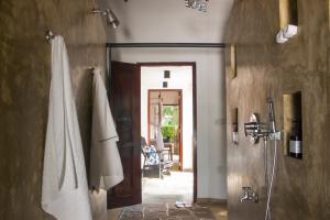 乌纳瓦图纳Why House的带淋浴的浴室和通往客房的门