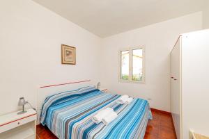 圣特奥多罗Residence Arcobaleno的白色的卧室设有床和窗户