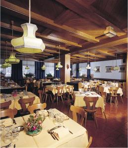 罗卡皮耶托雷Hotel Venezia的餐厅配有白色的桌椅和灯光
