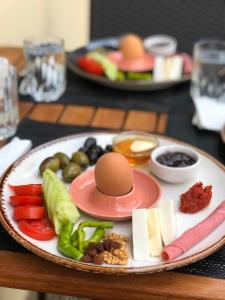 塞尔丘克Queen Bee Hotel的桌上有鸡蛋和蔬菜的盘子