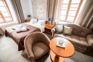 因德日赫城堡波特杉肯旅馆的酒店客房配有床、沙发和桌子。