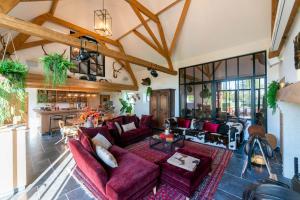 布鲁日霍伊夫德祖德霍克度假屋的一间带紫色沙发的客厅和一间厨房