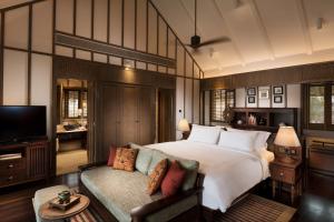 迪沙鲁Anantara Desaru Coast Resort & Villas的一间卧室配有一张大床和一张沙发