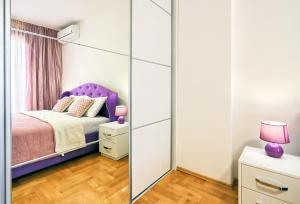 贝西奇Apartment Anatolia - Ruzica的一间卧室配有一张紫色的床和镜子