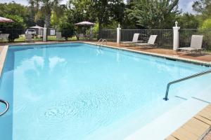 Henderson布罗布里奇智选假日酒店的一个带两把草坪椅的大型蓝色游泳池