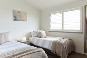 拜伦湾拜伦季公寓酒店的一间卧室设有两张床和窗户。