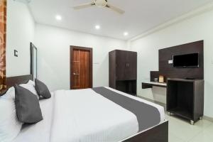 维沙卡帕特南Sri Raghavendra Inn的卧室配有白色的床和电视。