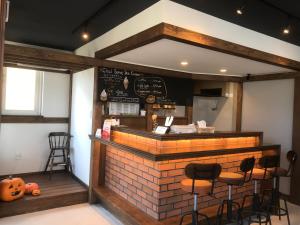 札幌Sapporo Guest House 庵 Anne的一间带砖台和凳子的餐厅