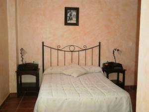 卡马雷纳德拉谢拉萨尔瓦多奥尔莫旅舍的卧室内的一张床位,配有两个床头柜和两张桌子