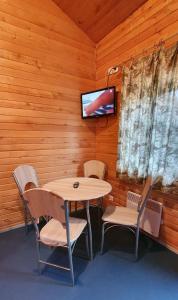 TuksiTuksi Health and Sports Centre的一间带桌椅和电视的用餐室