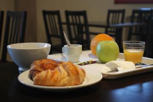 阿蒂斯蒙斯奥利高级酒店的一张桌子,上面有一块盘子,上面有羊角面包和水果