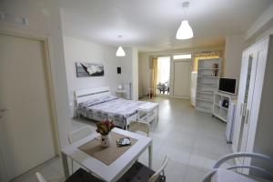 滨海波利尼亚诺Casa Mascagni的一间带床和桌子的客厅和一间房间