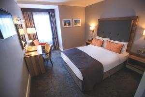 班特里韦斯特洛奇酒店及休闲中心的酒店客房设有一张大床和一张书桌。