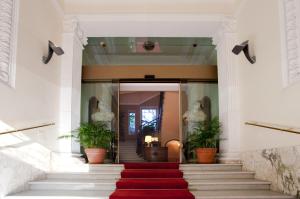 罗马阿尔德罗万迪城市套房酒店的一座种植了植物的建筑里,有红色地毯的楼梯