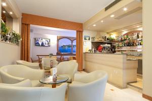 巴多利诺Hotel GARDENIA & Villa CHARME Adults Friendly 10Plus的一间设有白色椅子的餐厅和一间酒吧