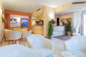巴多利诺Hotel GARDENIA & Villa CHARME Adults Friendly 10Plus的客厅配有白色的椅子和桌子