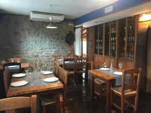 擞莫Posada La Llosa de Somo的餐厅设有木桌和椅子,拥有砖墙