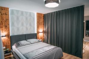 克拉科夫Vistula Terraces Apartment的一间卧室配有一张带绿帘的床