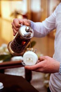 巴库Paradise Hotel Baku的一个人把瓶子放在咖啡壶里