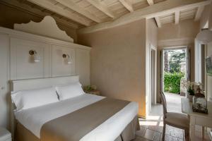 蒙蒂基亚里新宫殿酒店的一间卧室配有一张床、一张桌子和一个窗户。