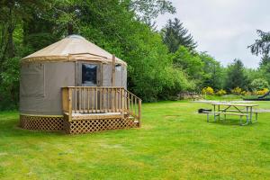 OceanviewLong beach Camping Resort Yurt 8的圆顶帐篷,配有桌子和野餐桌