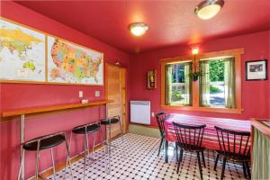 星期五港Juniper Lane Guest House的餐厅内带红色墙壁和椅子的酒吧