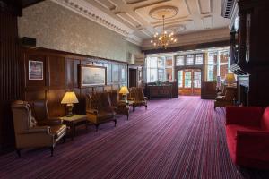 查尔伍德大不列颠罗斯山酒店的一间设有桌椅和吊灯的等候室