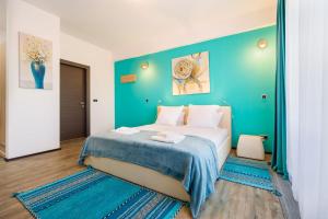 波亚纳布拉索夫Fabulous Panorama Silver Mountain Apartments的一间卧室设有一张蓝色墙壁的大床