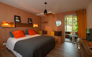 卡普费雷Le Lodge du Cap Ferret的一间卧室配有带橙色和蓝色枕头的床