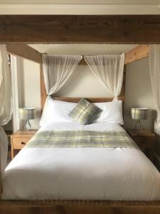 爱丁堡克雷格米勒公园18号旅馆的一间卧室配有一张带两盏灯的大型白色床。