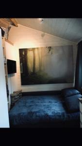 诺尔雪平Villa Lillgården with Sauna and Jacuzzi的一间设有一张床的客房,墙上挂着一幅画