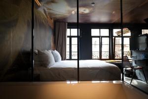 安特卫普奥卡瑟德尔酒店的一间卧室配有一张床和一面大镜子