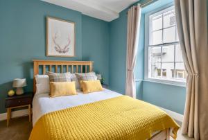 爱丁堡玫瑰公寓的蓝色的卧室设有床和窗户