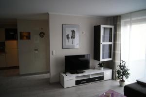 BleialfFerienwohnung Im Alftal, Bleialf的一间客厅,客厅的白色橱柜上配有电视