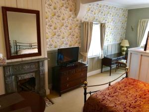 德比Durham Ox Ilkeston的一间卧室设有壁炉、电视和镜子