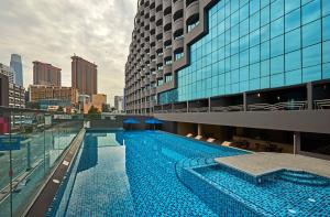 吉隆坡Swiss-Garden Hotel Bukit Bintang Kuala Lumpur的大楼前的大型游泳池