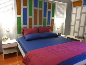大城班百脉精品酒店 的一间卧室配有一张大床和色彩缤纷的床头板