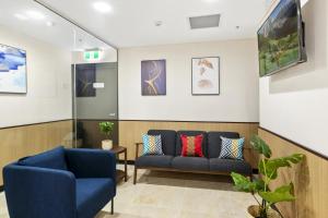 悉尼YEHS Hotel Sydney QVB的一间等待室,配有两把椅子和一张沙发