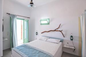 斯希努萨岛Ailouros Scenic Guest Houses的卧室配有一张床铺,墙上有一条支架