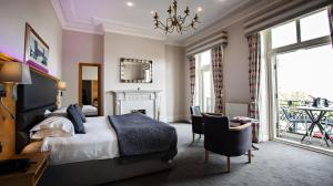 斯卡伯勒斯卡伯勒康帕斯皇冠Spa酒店的卧室配有一张床和一张桌子及椅子