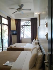 长滩岛新月广场酒店的一间卧室配有两张床和吊扇