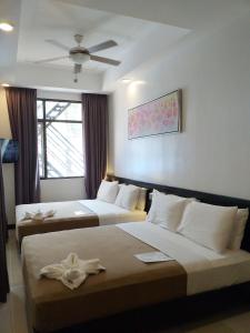 长滩岛新月广场酒店的酒店客房配有两张床和吊扇。